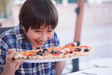 Boy holding pizza Stock Photo - Premium Royalty-Free, Code: 614-07194695
