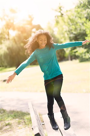 preteens playing outside - Young girl balancing on bench in park Stock Photo - Premium Royalty-Free, Code: 614-07194739