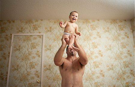 Grandfather holding baby granddaughter, low angle Stock Photo - Premium Royalty-Free, Code: 614-07194784