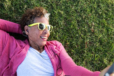 senior humour - Portrait of senior woman lying on grass wearing sunglasses Stock Photo - Premium Royalty-Free, Code: 614-07234928