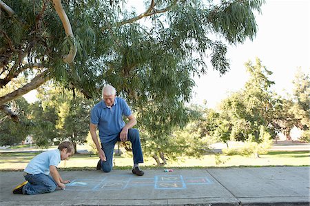 Grandfather and grandson drawing hopscotch Stock Photo - Premium Royalty-Free, Code: 614-07235019