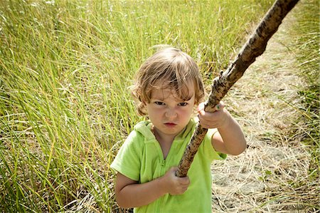 Portrait of female toddler holding long stick Stock Photo - Premium Royalty-Free, Code: 614-07240010