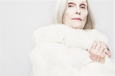 Cropped studio portrait of senior woman in white fur coat Stock Photo - Premium Royalty-Free, Code: 614-07240035