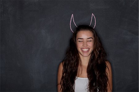 devil - Young woman by blackboard with horns Stock Photo - Premium Royalty-Free, Code: 614-07240134