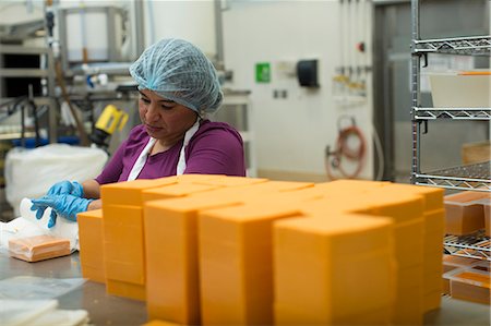 people working in factory - Woman packaging vegan cheese in warehouse Stock Photo - Premium Royalty-Free, Code: 614-07240188