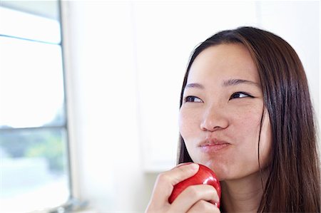 simsearch:614-07806265,k - Young woman in kitchen eating red apple Stock Photo - Premium Royalty-Free, Code: 614-07444000