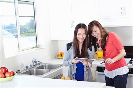 simsearch:649-07280729,k - Two young women in kitchen looking at digital tablet Stock Photo - Premium Royalty-Free, Code: 614-07444001