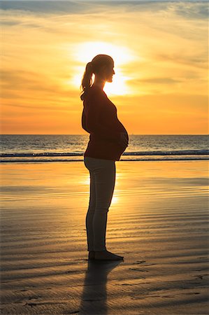 Pregnant mid adult woman on beach at sunset, San Diego, California, USA Photographie de stock - Premium Libres de Droits, Code: 614-07444043