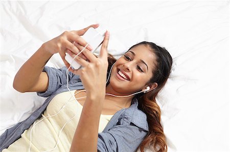 students bedroom - Young woman listening to music in bedroom Stock Photo - Premium Royalty-Free, Code: 614-07444094