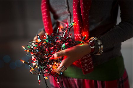 Close up of young woman holding tangle of christmas lights Stock Photo - Premium Royalty-Free, Code: 614-07444160