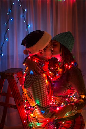 fun pictures christmas - Young couple wrapped in fairy lights at christmas Foto de stock - Sin royalties Premium, Código: 614-07444163