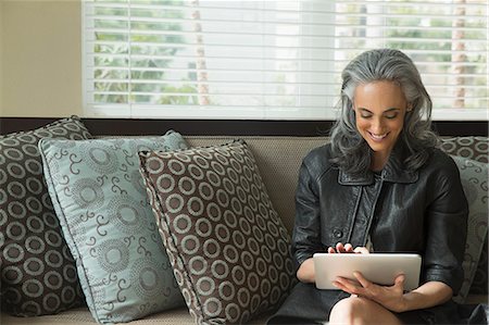 Woman using digital tablet on sofa Stock Photo - Premium Royalty-Free, Code: 614-07453268