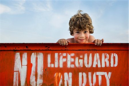 Portrait of boy and lifeguard sign, Long Beach, New York State, USA Stock Photo - Premium Royalty-Free, Code: 614-07486921