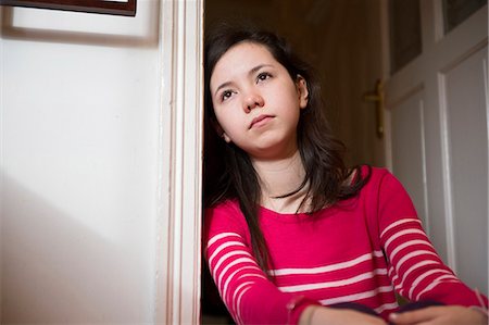 sad and missing someone - Girl leaning against doorway Stock Photo - Premium Royalty-Free, Code: 614-07487215