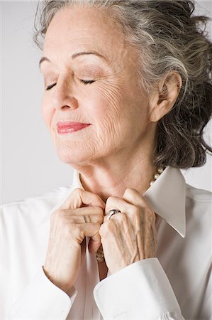 shirt collar - Portrait of senior woman, hands on collar, eyes closed Stock Photo - Premium Royalty-Free, Code: 614-07587689