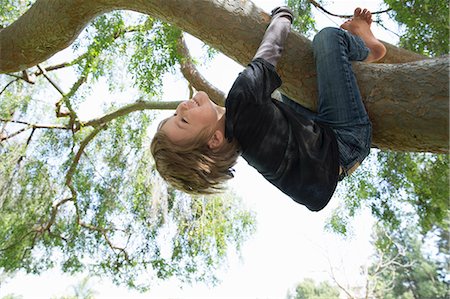 Upside down boy wrapped around tree branch Fotografie stock - Premium Royalty-Free, Codice: 614-07587697