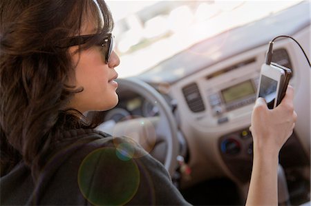 front seat - Young woman reading text on her cellphone in car Stock Photo - Premium Royalty-Free, Code: 614-07652279