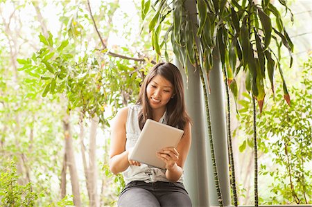 Young woman using digital tablet outdoors Stock Photo - Premium Royalty-Free, Code: 614-07652322