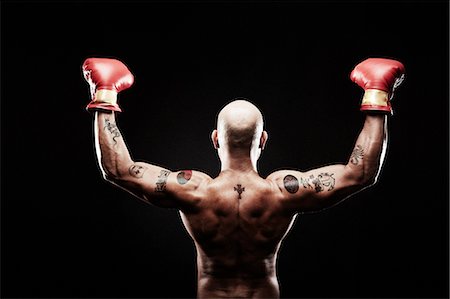 strong (human physical strength) - Boxer with arms raised, rear view Stock Photo - Premium Royalty-Free, Code: 614-07652419