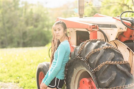 Portrait of teenage girl standing beside tractor Stock Photo - Premium Royalty-Free, Code: 614-07708259