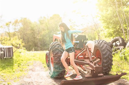 Teenage girl balancing on tractor Stock Photo - Premium Royalty-Free, Code: 614-07708260