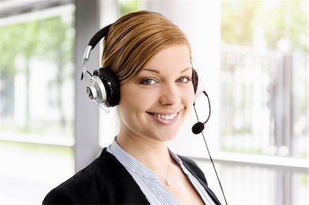 Portrait of young businesswoman in telephone headset Stock Photo - Premium Royalty-Free, Code: 614-07735181