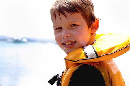 Close up portrait of smiling boy in lifejacket Foto de stock - Sin royalties Premium, Código: 614-07735206
