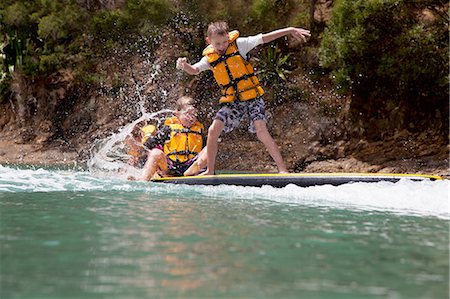 simsearch:614-08270379,k - Brothers and sister splashing from paddleboard at sea Stock Photo - Premium Royalty-Free, Code: 614-07735208