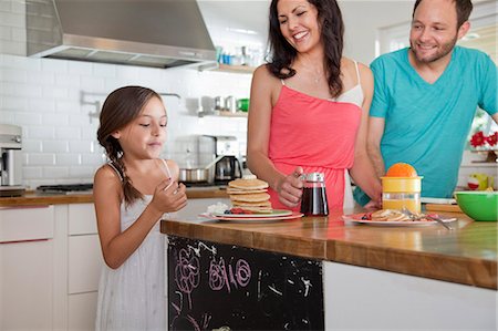 simsearch:614-06896477,k - Mid adult parents tempting daughter with pancakes at breakfast bar Stock Photo - Premium Royalty-Free, Code: 614-07735225