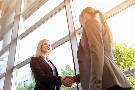 simsearch:649-07736470,k - Low angle view of two young businesswomen shaking hands Stock Photo - Premium Royalty-Free, Code: 614-07735315