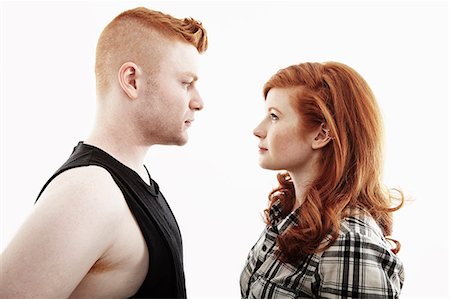 portrait white - Studio portrait of red haired young couple gazing face to face Stock Photo - Premium Royalty-Free, Code: 614-07735551