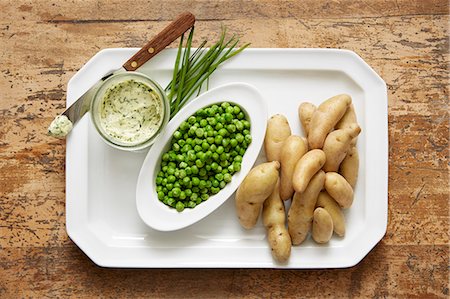 simsearch:6118-07808971,k - Fingerling potatoes and spring peas served with a chive compound butter Stock Photo - Premium Royalty-Free, Code: 614-07735613