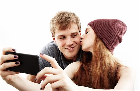 pose - Studio portrait of young couple taking selfie on smartphone Foto de stock - Sin royalties Premium, Código: 614-07768181