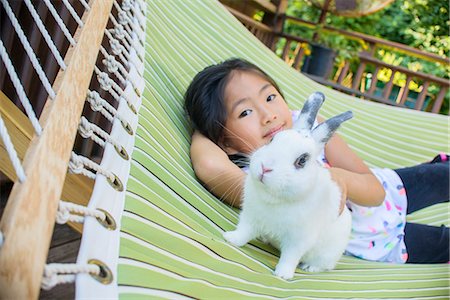 Young asian girl on hammock with pet rabbit Stock Photo - Premium Royalty-Free, Code: 614-07806359