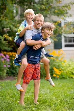 simsearch:649-08004031,k - Three boys playing piggyback in garden Stock Photo - Premium Royalty-Free, Code: 614-07806474