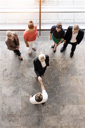 Overhead view of businesswomen and team meeting client Stock Photo - Premium Royalty-Free, Code: 614-07911907