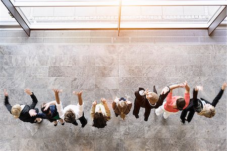 small business 20s - Overhead view of business team in a row jumping for joy Stock Photo - Premium Royalty-Free, Code: 614-07911912