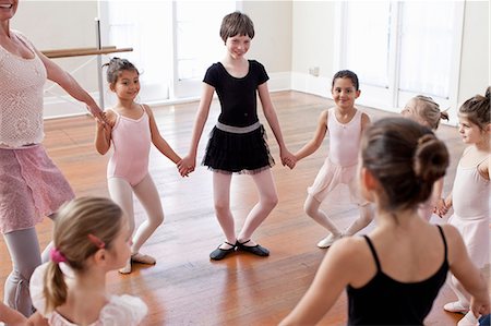 pre teens in leotards - Children and teacher in a circle practicing ballet in ballet school Stock Photo - Premium Royalty-Free, Code: 614-07911977