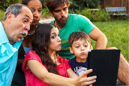 family reunion - Three generation family using digital tablet in garden Stock Photo - Premium Royalty-Free, Code: 614-08000174
