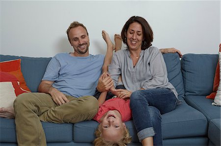 parent tickle child - Parents with son sitting on sofa Stock Photo - Premium Royalty-Free, Code: 614-08000357