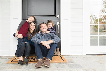 Portrait of parents and two children sitting at front door Stock Photo - Premium Royalty-Free, Code: 614-08030656