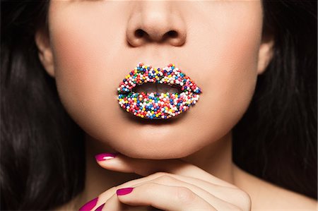Mid adult woman with sprinkles on lips Stock Photo - Premium Royalty-Free, Code: 614-08030704