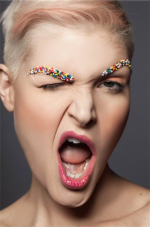 sneer - Young woman with sprinkles on eyebrows, winking Stock Photo - Premium Royalty-Free, Code: 614-08030715