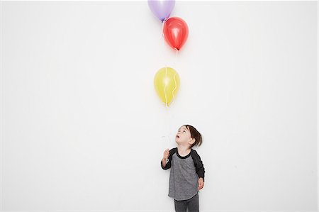 simsearch:614-06897440,k - Portrait of cute male toddler holding and gazing up at three helium balloons Stock Photo - Premium Royalty-Free, Code: 614-08030882