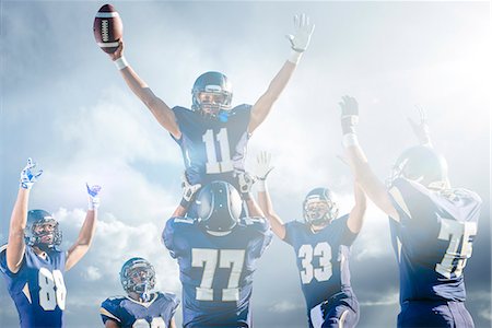 Teenage and young male American football team celebrating on pitch Stock Photo - Premium Royalty-Free, Code: 614-08031095