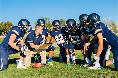 people sports in america - Coach writing on whiteboard for teenage and young male American football team Stock Photo - Premium Royalty-Free, Code: 614-08031096