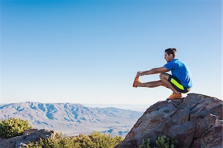 Male trail runner stretching legs on rock on Pacific Crest Trail, Pine Valley, California, USA Foto de stock - Sin royalties Premium, Código: 614-08065997