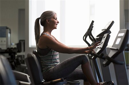 fitness older women gym - Mature woman training on gym machine using touchscreen control Foto de stock - Sin royalties Premium, Código: 614-08066135