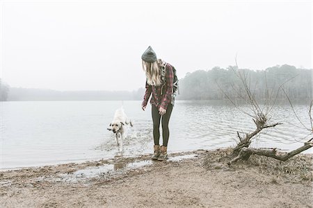 Young woman playing with her dog on misty lakeside Photographie de stock - Premium Libres de Droits, Code: 614-08081225