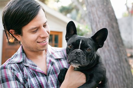 pet owners and their pets - Portrait of young man carrying dog Stock Photo - Premium Royalty-Free, Code: 614-08081245